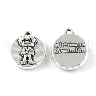 Colgante de aleación, oval, con niño por el anverso y mensaje “Mi primera comunión” por el reverso, 18x14x4 mm.