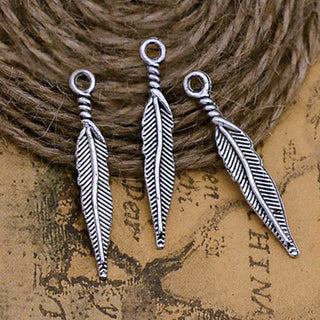 Dije Pluma Estilizada Estilo Tibetano Tono Plata Envejecida 29x5mm | 16 uds